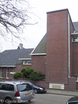 Linker ingangpartij. Achter de struiken haaks op de rooilijn ligt de deur.
<br/>
Corrie Groen- Pickhard, 2016-06-12